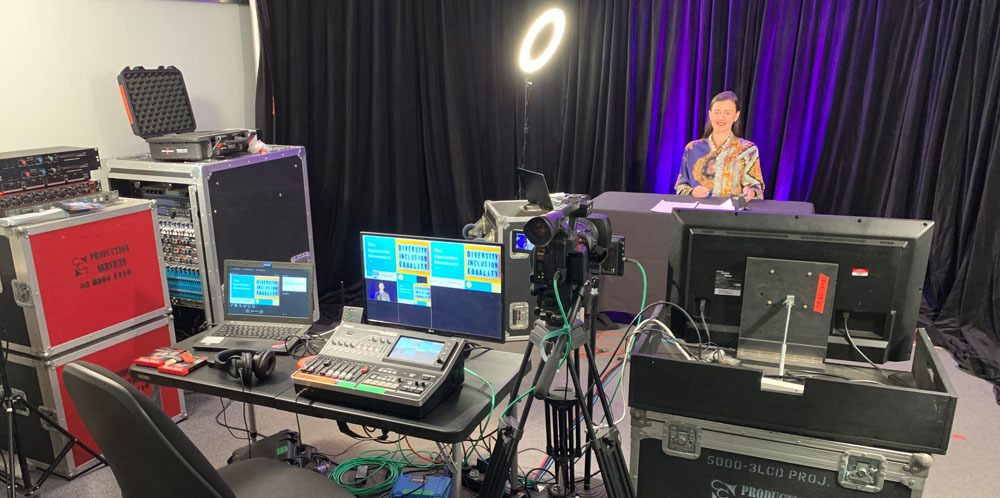 An event production desk set up, with a lady standing in front of it.